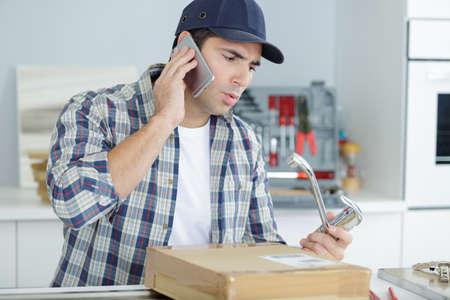 man on a phone call in the kitchenの写真素材