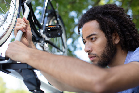 a man installs a children bicycle on a car