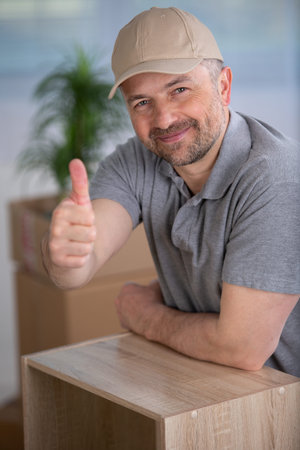 successful furniture assembly worker shows thumbs upの写真素材