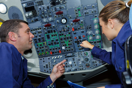 instructor teaching female engineer a cockpit