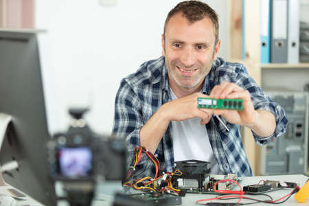 vlogger recording computer repair on cameraの写真素材