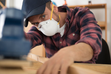 man wearing dust mask to use a sanderの写真素材