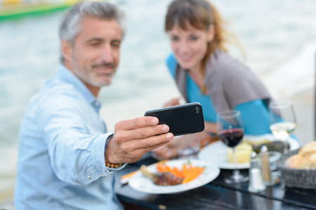 they arer taking picture during mealの写真素材