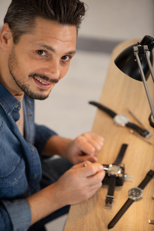 happy watchmaker is repairing customerss watchesの写真素材