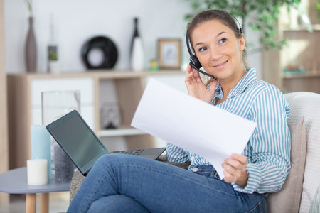a woman on the sofa communicating by handsfree headset