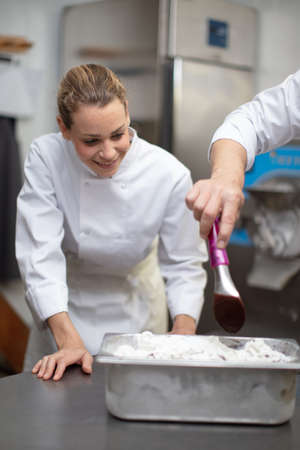female worker is working on ice cream maker machineの写真素材