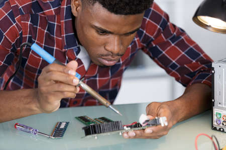 computer specialist repairing pc late at nightの写真素材