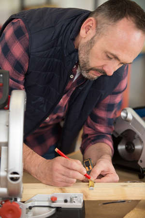 building contractor worker using hand held worm drive circular sawの写真素材