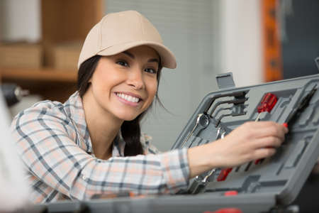 woman next to opened case with instruments or toolboxの写真素材
