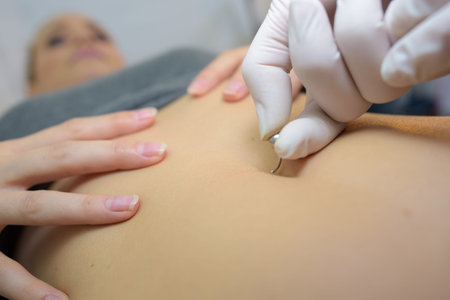 she is putting a navel piercing