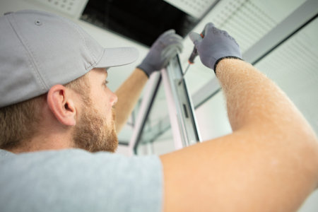 construction worker installing window in houseの写真素材