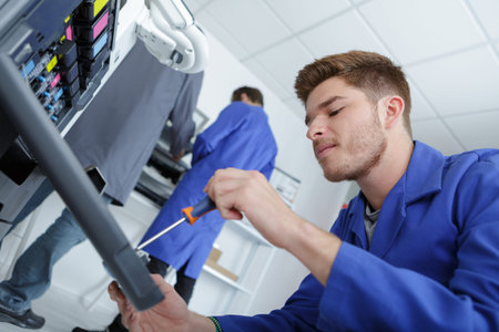 man fixing cartridge in printer machine at office