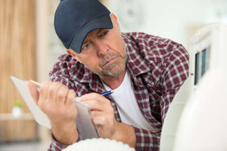 a male technician taking notesの写真素材