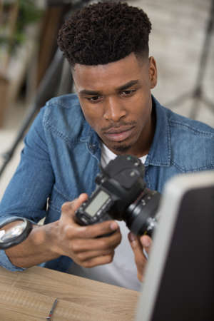 male technician assembling a dslr cameraの写真素材