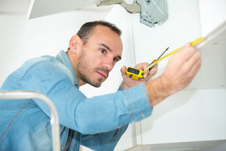 man fixing the cupboard doorの写真素材
