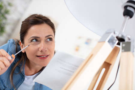 young beautiful woman twists a bulbの写真素材