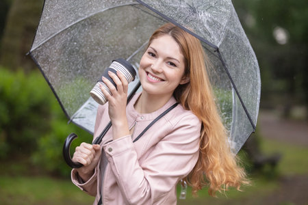 cheerful woman in the street drinking morning coffee