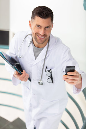 doctor using cellphone at hospital stairs