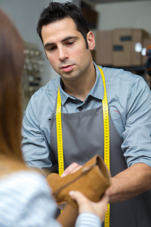 a male cobbler with customer