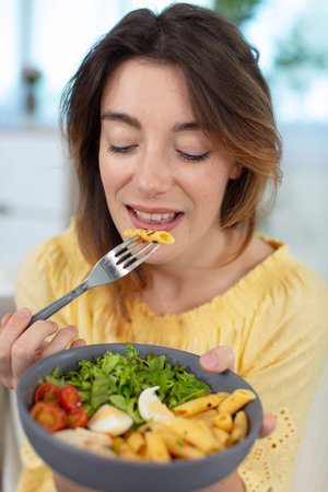 pretty lady enjoys a pasta saladの写真素材