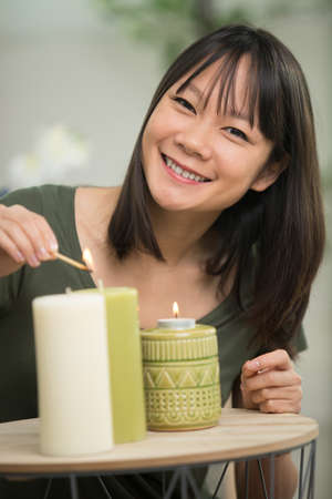 happy young woman lighting candleの写真素材