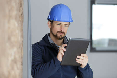 man build uses a tablet in siteの写真素材