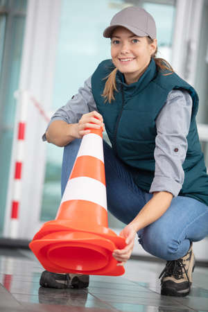 young woman holding a traffic coneの写真素材