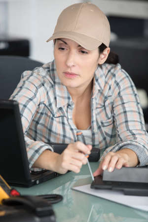 female technician working on appliance at her deskの写真素材