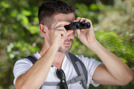 handsome traveler man with binoculars in nature