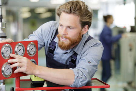 inspector checking pressure gauges on heating boiler systemの写真素材