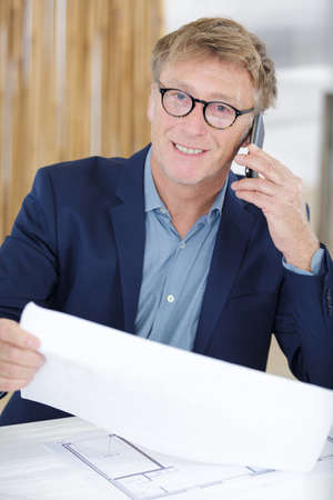 a man woking on blueprintsの写真素材