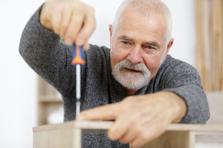a senior man screwing furnitureの写真素材
