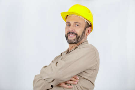 engineer worker wears yellow helmet with arm crossedの写真素材