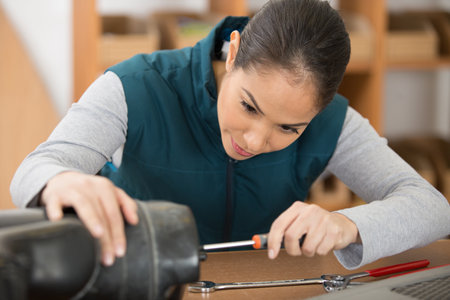concentrated female repairman repairing somethingの写真素材