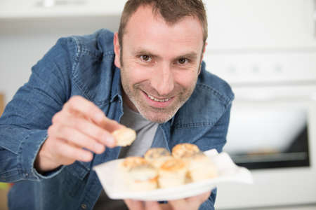 man offering pastry appetizersの写真素材