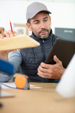 craftsman using his tablet computer in a construction siteの写真素材
