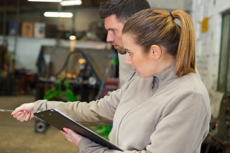 colleagues in workshop pointing into distanceの写真素材