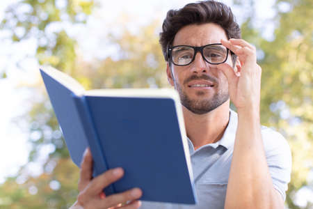 man reading a book in the parkの写真素材