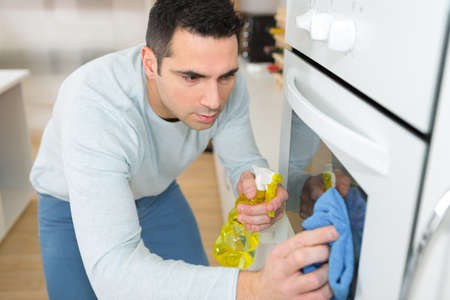 man cleaning ovenの写真素材