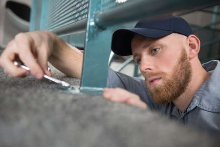 close-up of a carpet fitters hand installing gray carpet screwdriverの写真素材