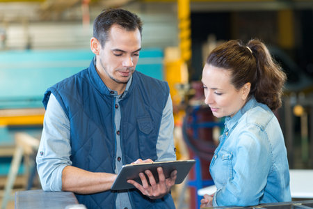 male worker and female coworker looking at clipboard