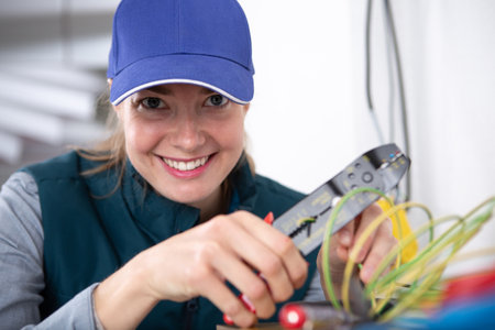 happy woman laborer is cutting pipesの写真素材