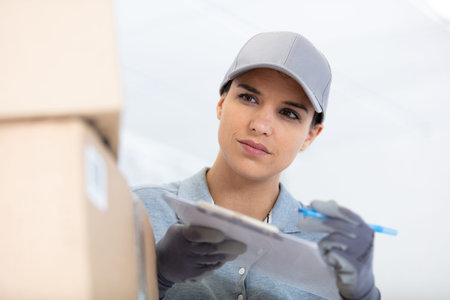 portrait of female delivery driver with clipboard