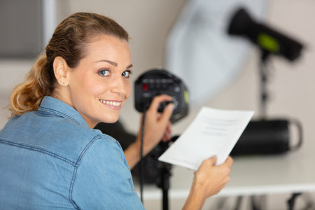 young female photographer setting her studio flash