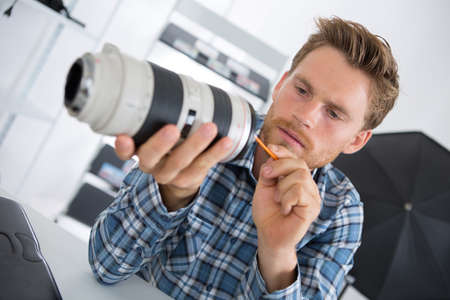 young technician cleaning camera lensの写真素材