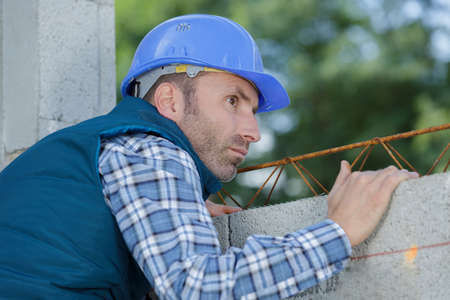 foreman builder inspecting concrete construction workの写真素材
