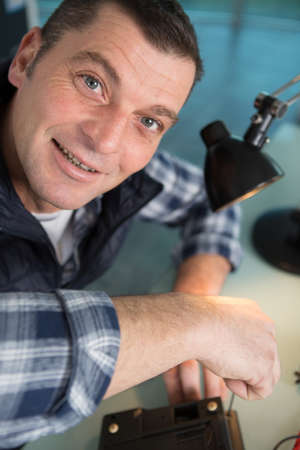 happy technician screws in a cooling fanの写真素材