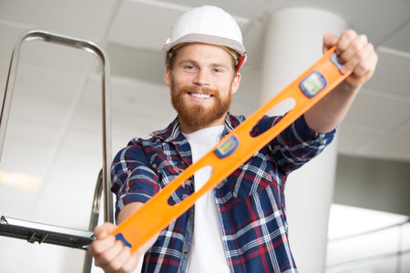 bubble level held by smiling builder