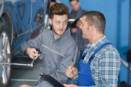 portrait of mechanic supervising apprentices work