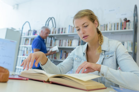 woman researching in books in library